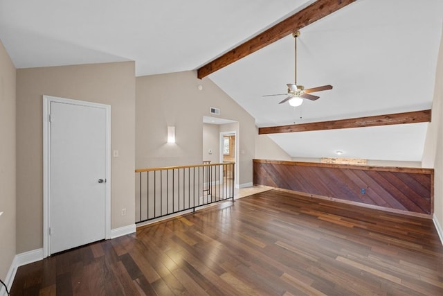 unfurnished room featuring visible vents, baseboards, a ceiling fan, wood finished floors, and vaulted ceiling with beams