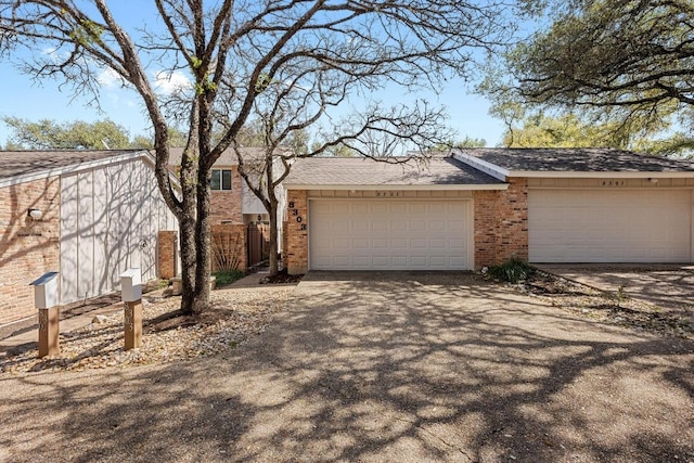 view of front facade featuring a garage, fence, aphalt driveway, and brick siding