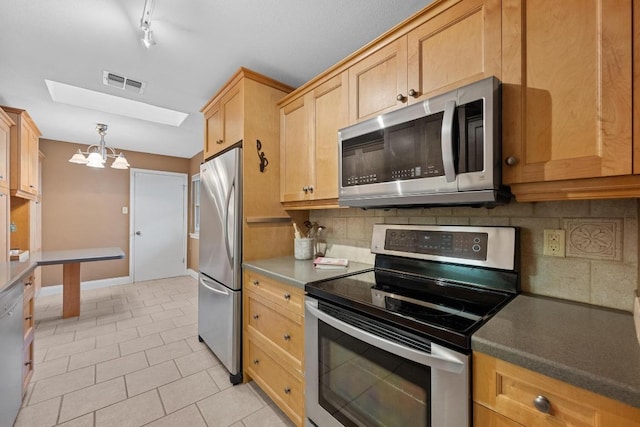 kitchen with light tile patterned floors, a notable chandelier, stainless steel appliances, visible vents, and light brown cabinetry