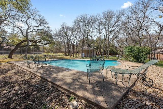 pool with an outbuilding, fence, and a patio