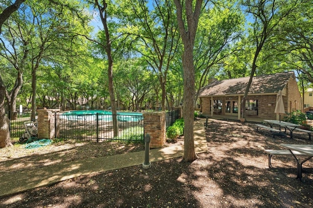 view of home's community featuring fence and a swimming pool