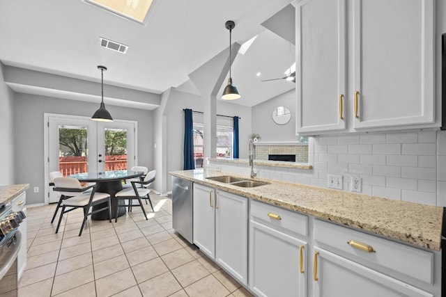 kitchen featuring light tile patterned flooring, stainless steel appliances, a sink, visible vents, and decorative backsplash