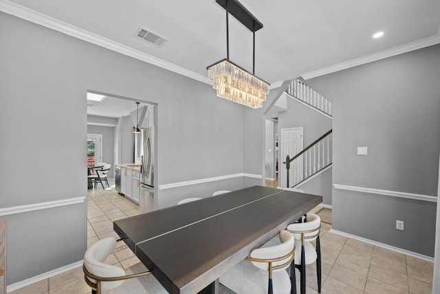 dining area with light tile patterned floors, visible vents, ornamental molding, and baseboards