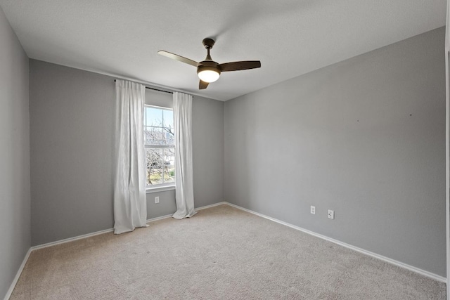 unfurnished room featuring carpet flooring, a ceiling fan, and baseboards