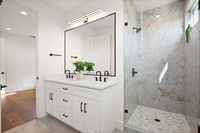 full bath featuring recessed lighting, a marble finish shower, and double vanity