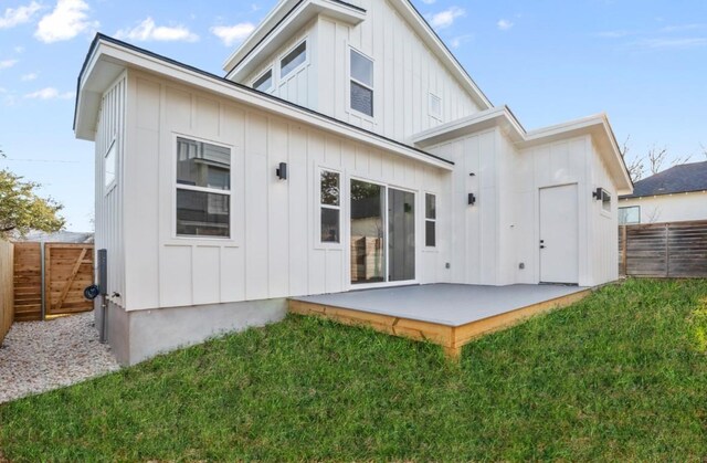 rear view of house with board and batten siding and a patio area