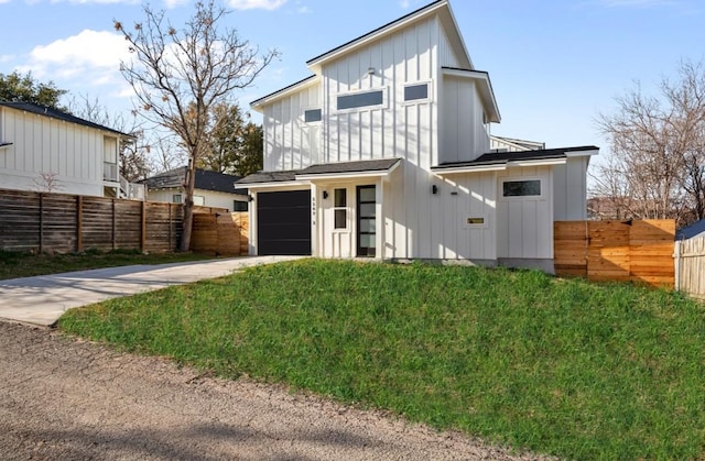 rear view of property featuring board and batten siding, concrete driveway, and an attached garage
