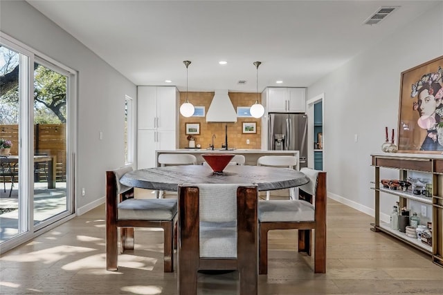 dining area with light wood-style flooring, recessed lighting, visible vents, and baseboards