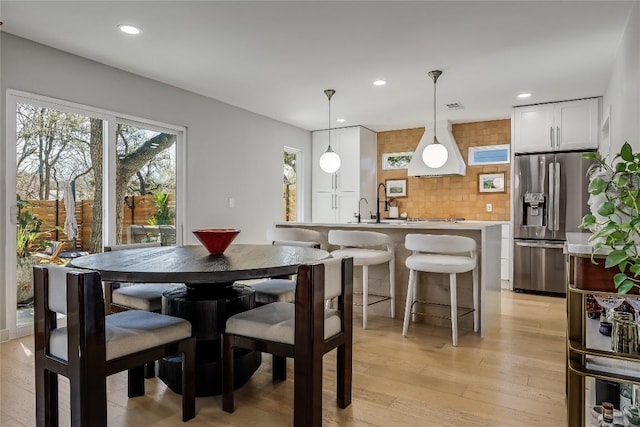 dining space with light wood finished floors, plenty of natural light, and recessed lighting