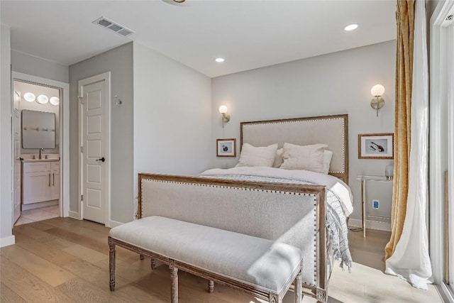 bedroom with recessed lighting, a sink, visible vents, light wood-type flooring, and ensuite bath