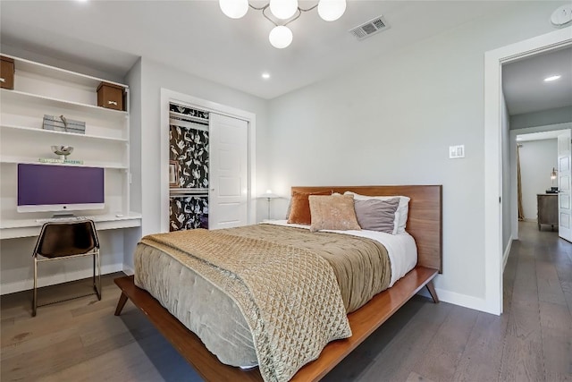 bedroom with baseboards, a closet, visible vents, and wood finished floors