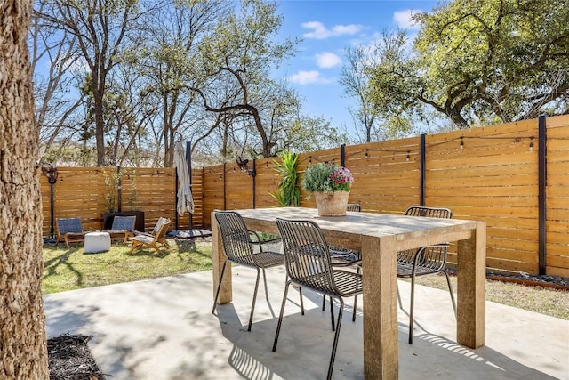 view of patio with a fenced backyard and outdoor dining space