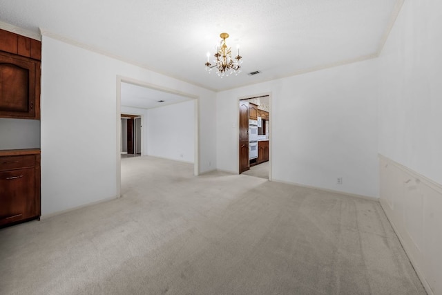 empty room featuring light carpet, baseboards, visible vents, an inviting chandelier, and crown molding