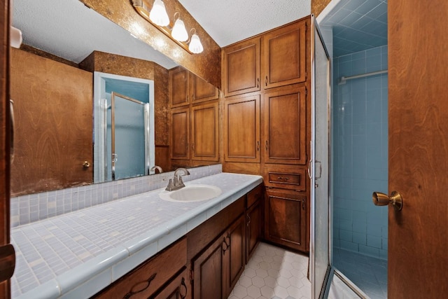 full bath with a shower stall, vanity, and tile patterned floors