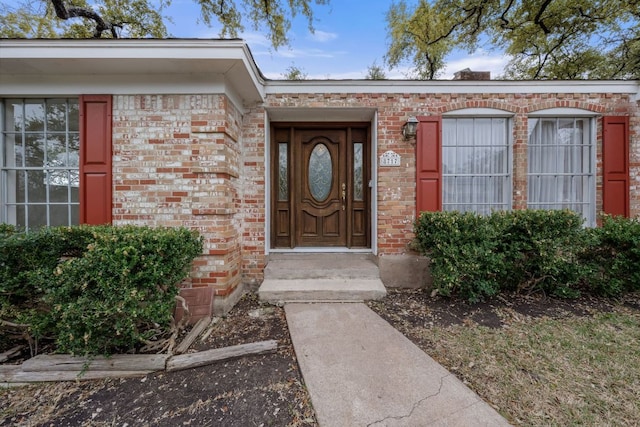 view of exterior entry featuring brick siding