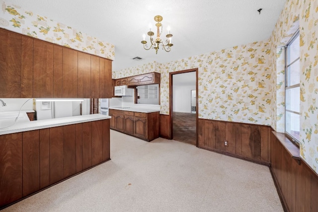 kitchen with wallpapered walls, white microwave, and a wainscoted wall