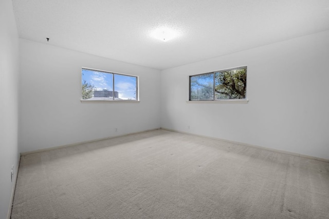 unfurnished room with a wealth of natural light and carpet flooring