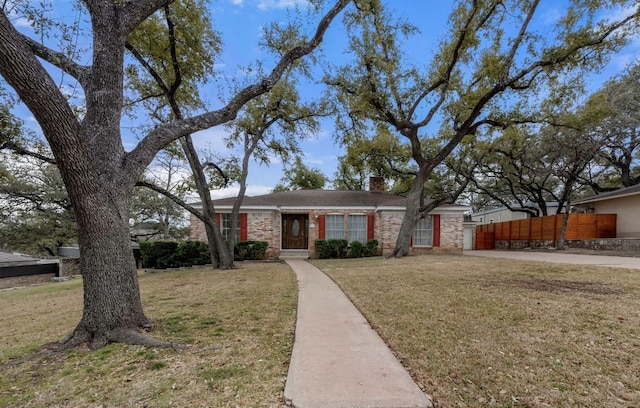 view of front of home with a front lawn, a chimney, and fence