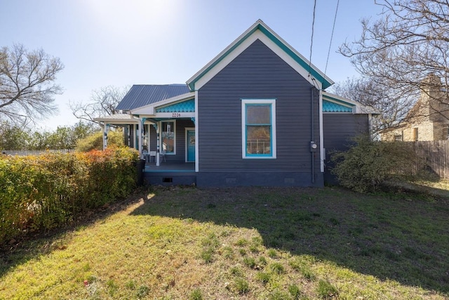 rear view of property featuring crawl space, covered porch, metal roof, and a yard