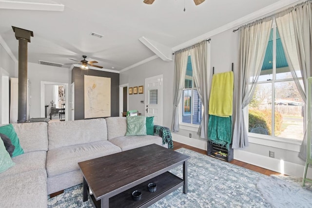 living room with baseboards, visible vents, a ceiling fan, wood finished floors, and crown molding