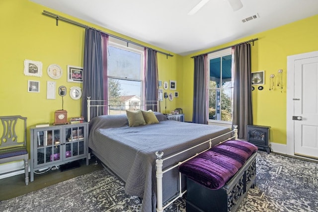 bedroom with multiple windows, visible vents, and a ceiling fan