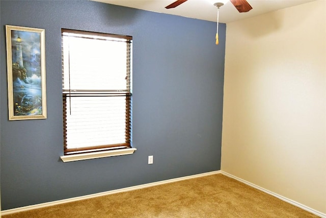 spare room featuring carpet, baseboards, and a ceiling fan