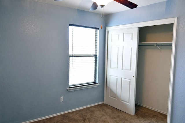 unfurnished bedroom with carpet floors, a closet, a ceiling fan, and baseboards