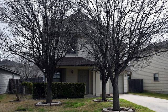 view of front of property featuring a garage, concrete driveway, roof with shingles, and fence