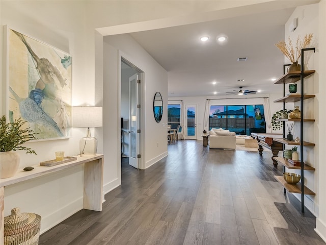 corridor with recessed lighting, dark wood finished floors, visible vents, and baseboards