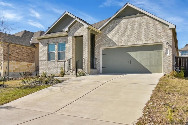 craftsman house featuring a garage, driveway, and brick siding