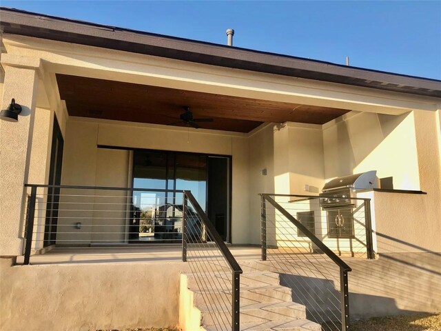 property entrance featuring exterior kitchen, a ceiling fan, and stucco siding