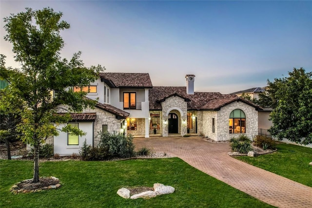 1208 Watercliffe Dr, Lago Vista, TX 78645 - view of front facade featuring stone siding, decorative driveway, a lawn, and stucco siding