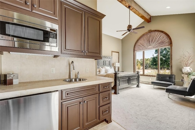 1208 Watercliffe Dr, Lago Vista, TX 78645 - kitchen with vaulted ceiling with beams, light countertops, stainless steel microwave, light carpet, and a sink