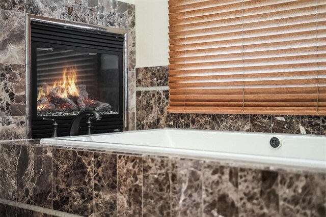 1208 Watercliffe Dr, Lago Vista, TX 78645 - details featuring a relaxing tiled tub and a glass covered fireplace