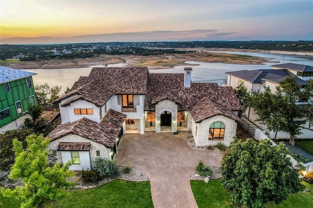 1208 Watercliffe Dr, Lago Vista, TX 78645 - view of front facade with a water view, stone siding, and decorative driveway