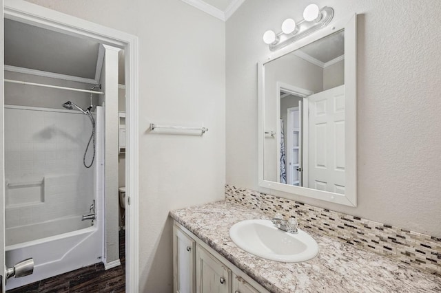 bathroom with bathtub / shower combination, toilet, ornamental molding, vanity, and wood finished floors