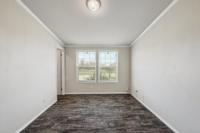 spare room featuring dark wood-style flooring, crown molding, and baseboards