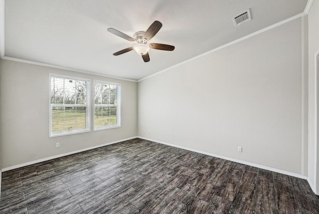 spare room featuring crown molding, dark wood finished floors, visible vents, ceiling fan, and baseboards