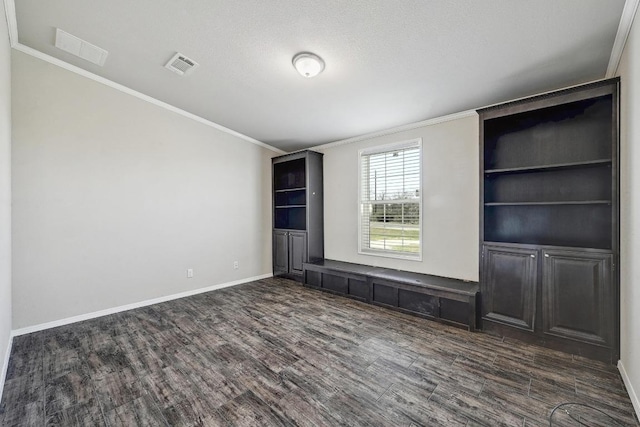 unfurnished bedroom featuring dark wood-style floors, baseboards, visible vents, and ornamental molding