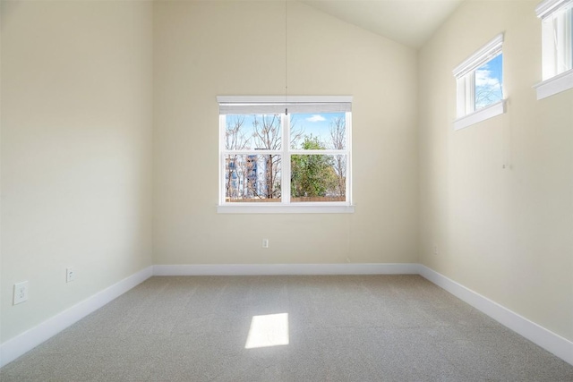 unfurnished room featuring light colored carpet, vaulted ceiling, and baseboards