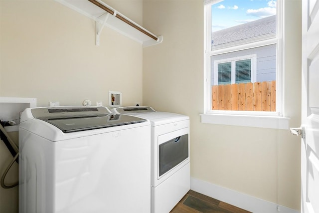 laundry room with laundry area, baseboards, dark wood-type flooring, and washing machine and clothes dryer