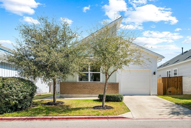 view of property hidden behind natural elements featuring driveway, brick siding, an attached garage, and fence