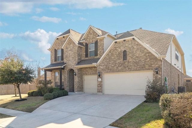 view of front of house with a garage, concrete driveway, brick siding, and fence