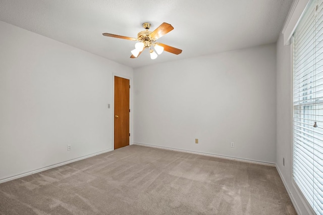 carpeted empty room featuring a ceiling fan