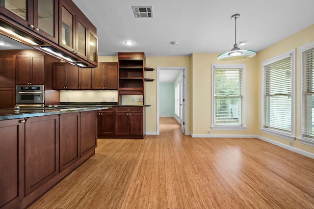 kitchen with open shelves, dark countertops, visible vents, light wood-style floors, and oven