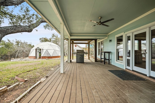 deck with area for grilling and a ceiling fan