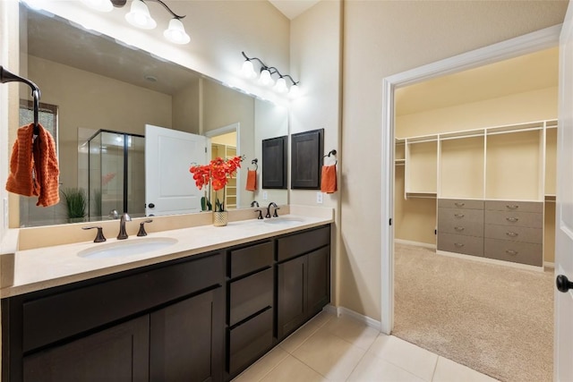 bathroom with a stall shower, a sink, and a walk in closet