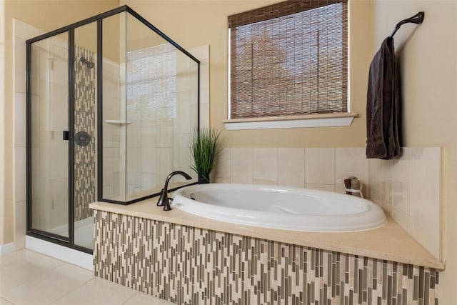 bathroom featuring a stall shower, a bath, and tile patterned floors