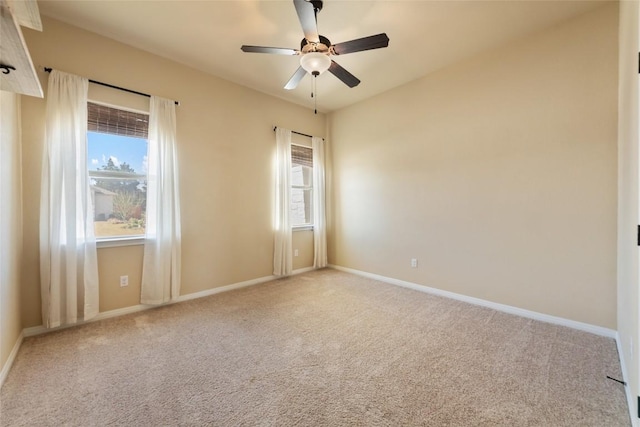 carpeted empty room featuring ceiling fan and baseboards