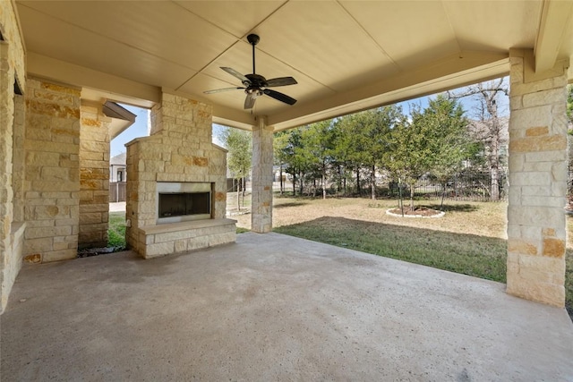 view of patio with a ceiling fan and an outdoor stone fireplace